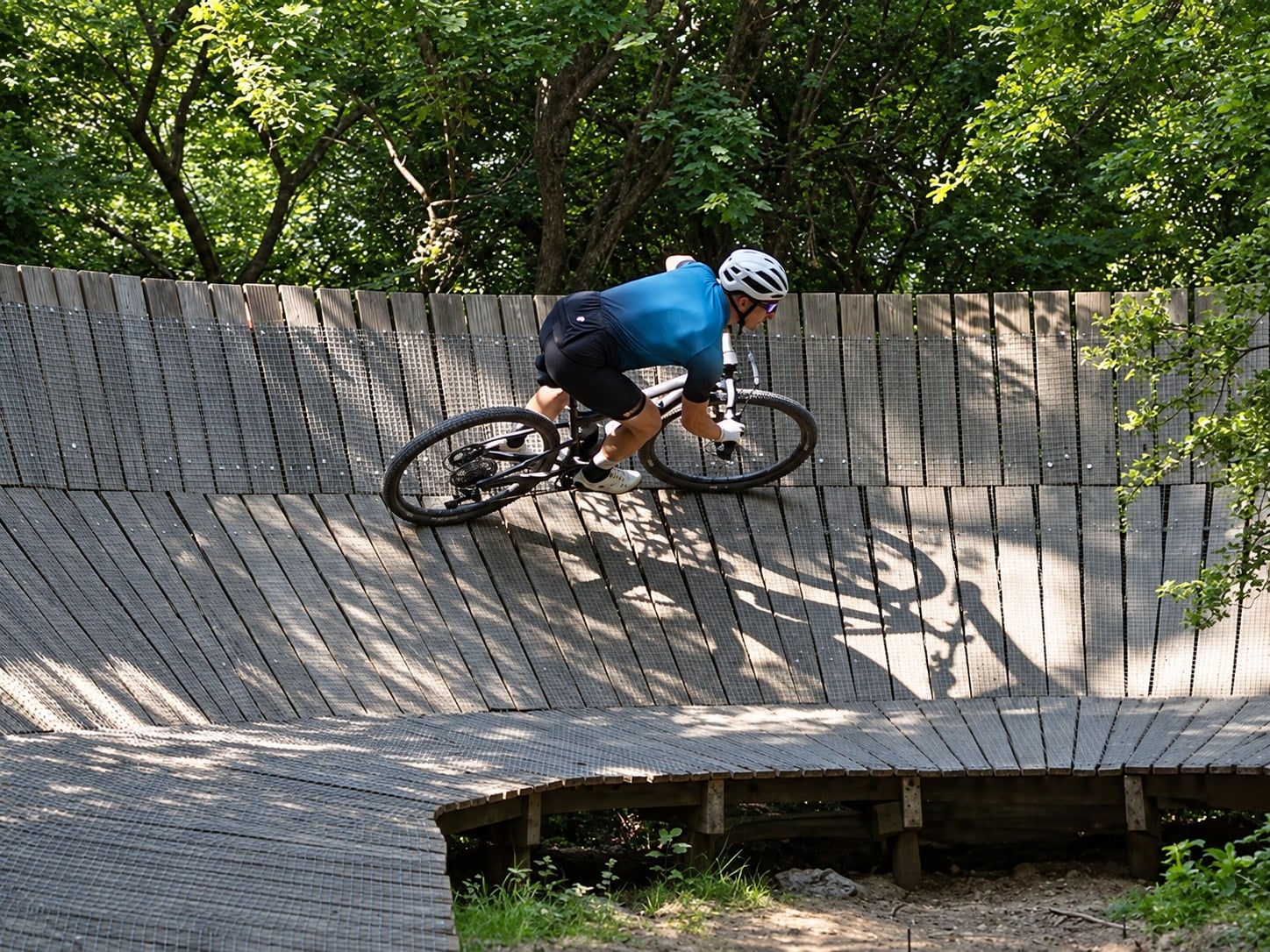 Mountainbiker op een houten steilwand in het bos